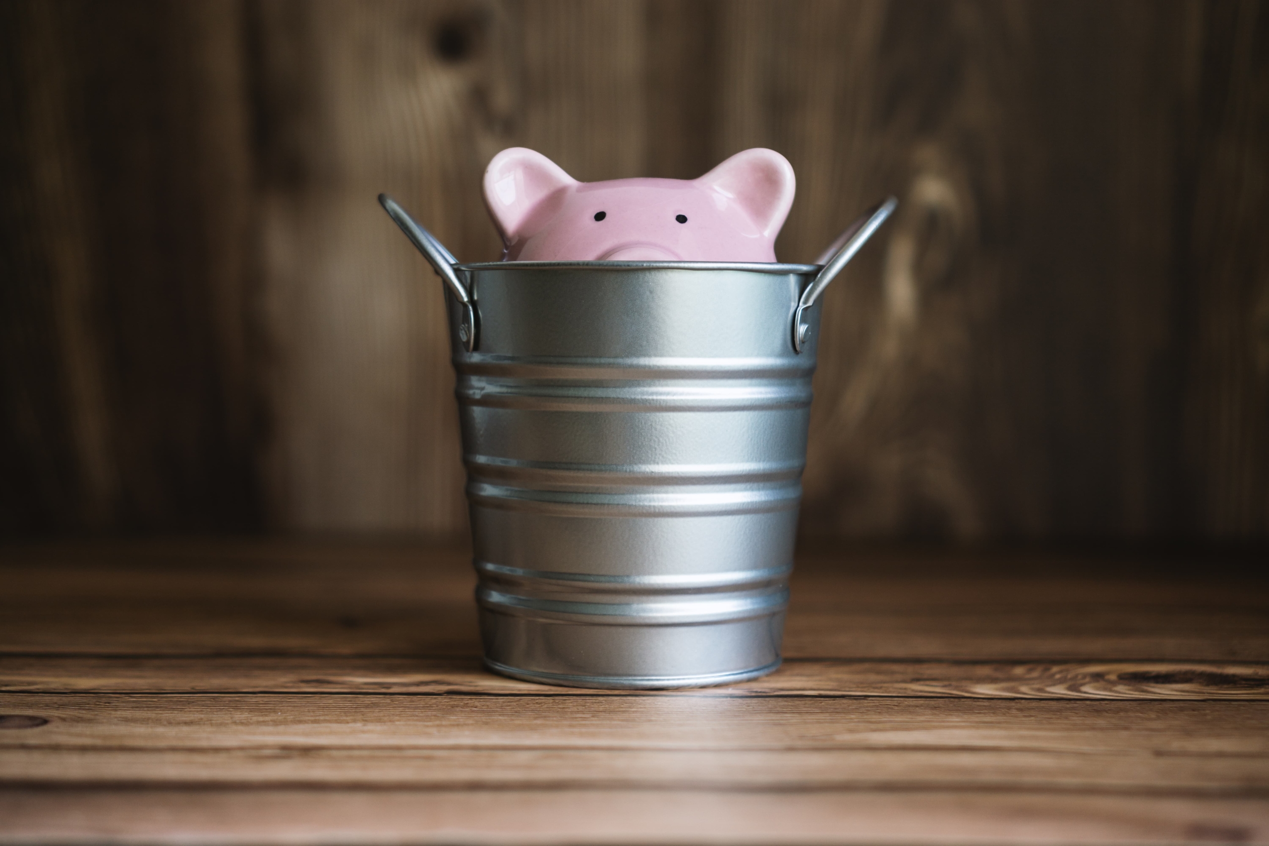 Piggy Bank Sinking Inside Steel Bucket